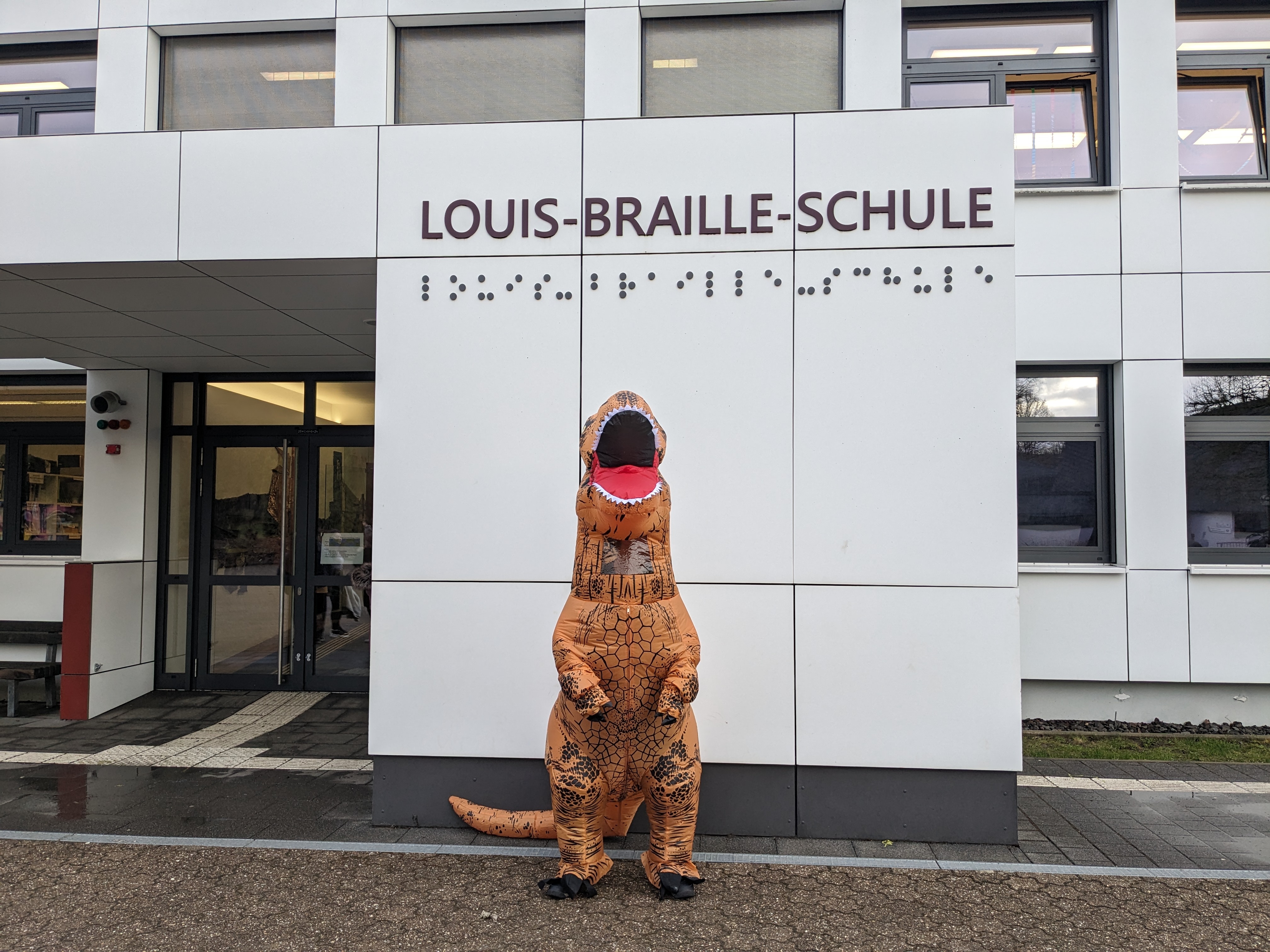 Sch%C3%BCler%20in%20T-Rex%20Kost%C3%BCm%20vor%20dem%20Schulgeb%C3%A4ude Sch%C3%BCler%20in%20T-Rex%20Kost%C3%BCm%20vor%20dem%20Schulgeb%C3%A4ude